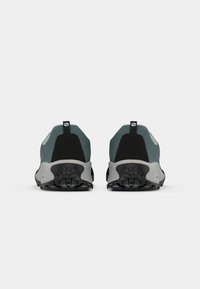Idrettssko med et design i teal og svart, med en teksturert overdel, bakre trekkstropp og en svart gummisåle med mønster for godt grep.