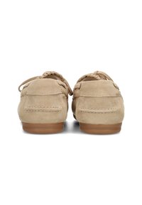 Beige suède mocassins met een gladde textuur, ronde neus en decoratieve veters. Bruine rubberen zolen.