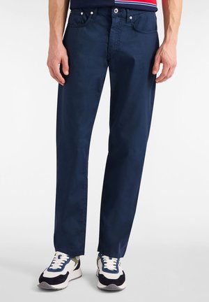 Marineblauwe chinos met een rechte snit, gemaakt van katoenen stof, voorzien van voorzakken en een gulp met rits, gecombineerd met kleurrijke sneakers.