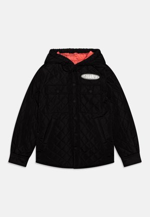 Veste noire matelassée avec capuche, deux poches poitrines, boutons-pression et doublure corail avec un patch logo sur le devant.