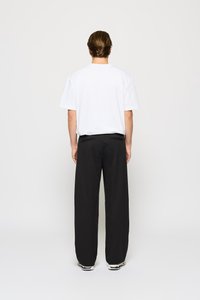 White short-sleeve t-shirt paired with black wide-leg pants. The outfit features a relaxed fit, simple design, and no visible patterns or accents.