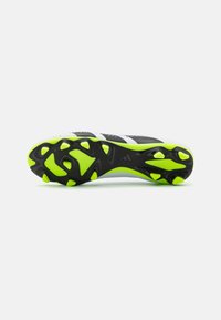 Sole di scarpa sportiva in bianco e nero con accenti di verde neon, caratterizzata da tacchetti modellati per la trazione, una superficie testurizzata e un design aerodinamico.