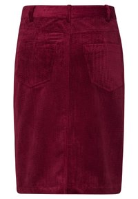 Burgundy corduroy skirt featuring a textured surface, two rear pockets, and a belt looped waistband. Straight cut with a hemmed bottom.