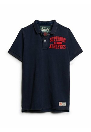 Marineblaues Polohemd, kurzärmlig, mit einem roten "SUPERDRY ATHLETICS" Logo, zwei Knöpfe an der Knopfleiste und einem Logopatch am Saum.