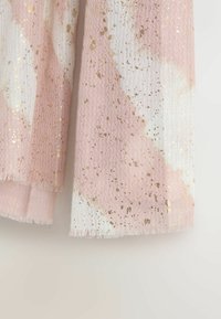 Lys rosa og hvidt mønstret stof med en bølget tekstur, der har gyldne prikker og frynsede kanter.