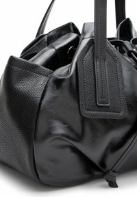 Bolso de mano de cuero negro con un acabado liso y brillante, y un patrón texturizado en un lado. Presenta asas dobles y un detalle de cierre ajustable.