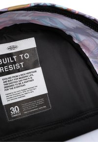 Eastpak Day Pak'r ryggsäck med svart inredning, utrustad med ett textilmärke som beskriver hållbarhet och design för vardagligt bruk.