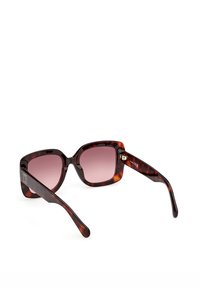 Firkantede brune solbriller med gradientbrune linser og tykke stel, vist i en vinkel mod en hvid baggrund.