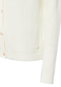 Detailní záběr na bílý pletený cardigan s dlouhým rukávem a béžovými knoflíky podél přední strany.