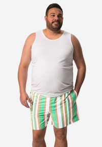 Vit ärmlös linne topp i kombination med flerfärgade randiga badshorts i grön, orange och vit. Shortsen har sidofickor.