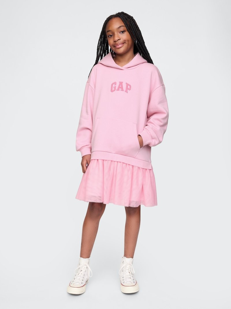 Roza dukserica s "GAP" logotipom, sprijeda s kenguruvim džepom, uparena s slojevitom roza tilom haljinom i bijelim tenisicama na visoku petu.