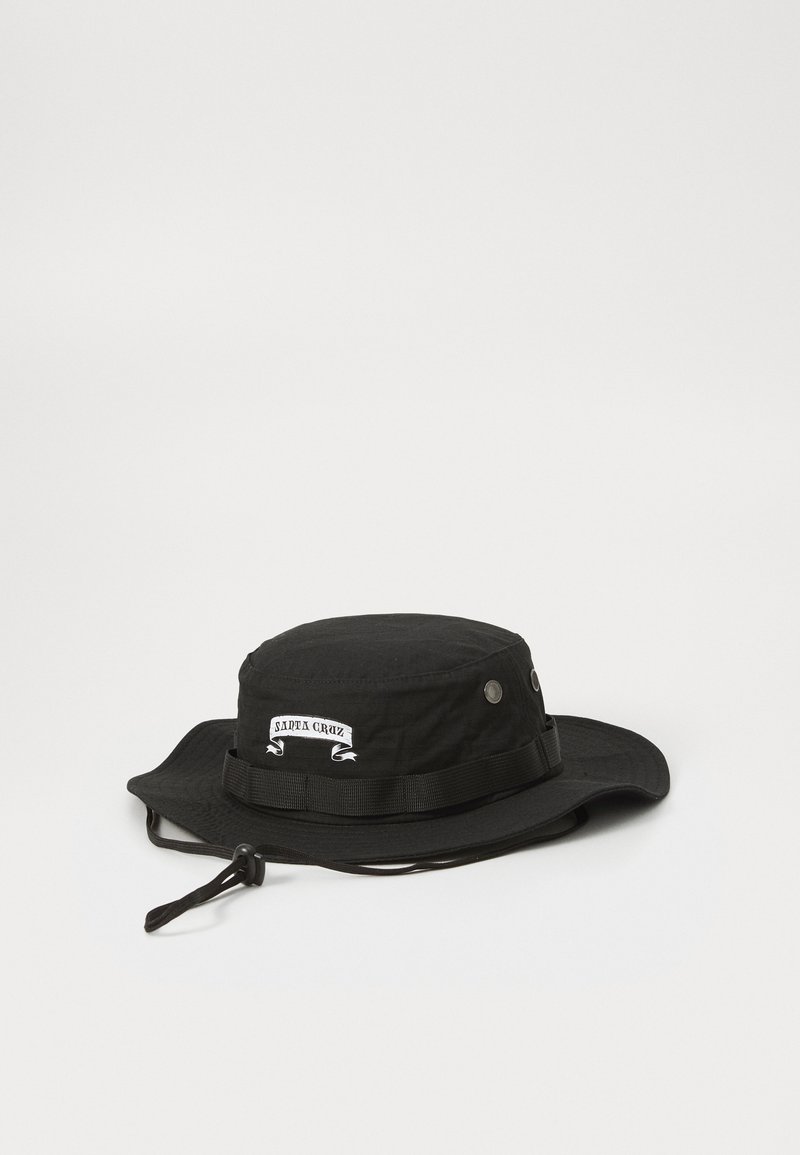 Cappello a secchiello nero realizzato in tessuto leggero, con una corona rotonda, una visiera larga, una fascia regolabile e un logo "Santa Cruz" sulla banda.