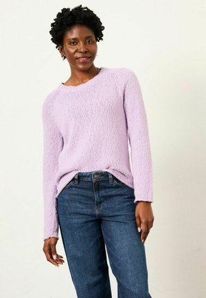 Helllila, strukturierter Strickpullover mit langen Ärmeln, kombiniert mit dunkelblauen Jeans. Verfügt über einen Rundhalsausschnitt und einen leichten Seitenschlitz am Saum.