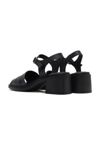 Black leather sandals featuring a rounded toe, padded strips, and a chunky ribbed heel. Adjustable ankle strap with metal buckle accents.
