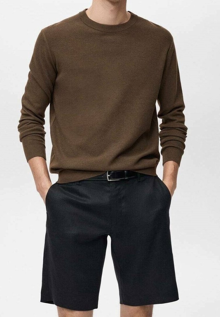 Pull marron texturé à manches longues et col rond, associé à un short noir, tous deux à coupe décontractée avec des poches latérales.