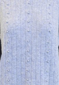 Ljust bl�å stickad tröja med ribbad struktur och dekorativa pärldetaljer jämnt fördelade över framsidan.