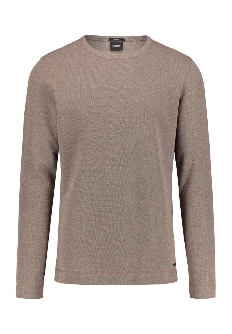 Chemise à manches longues de couleur brun clair, confectionnée en tissu texturé, avec un col rond et des détails de coutures discrètes sur l'ourlet et les manches.