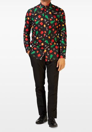 Camisa negra de botones con un estampado festivo de regalos rojos, árboles verdes, bastones de caramelo y copos de nieve. Combinada con pantalones de vestir negros y zapatos.