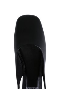 Black leather open-toe shoe with a smooth texture and a minimalist design, featuring a wide strap and a smooth interior lining.
