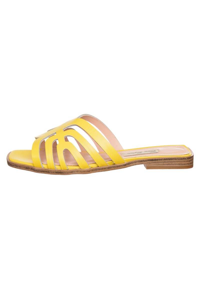 Gele slidesandalen met meerdere transparante uitsparingen, platte zool en een gladde leren afwerking. Lichtbruine, textuur geprofileerde buitenzool.