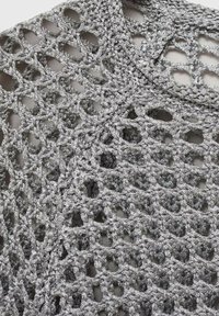 Tissu crocheté gris argent avec motif en dentelle ouverte et boucles et points complexes et interconnectés.