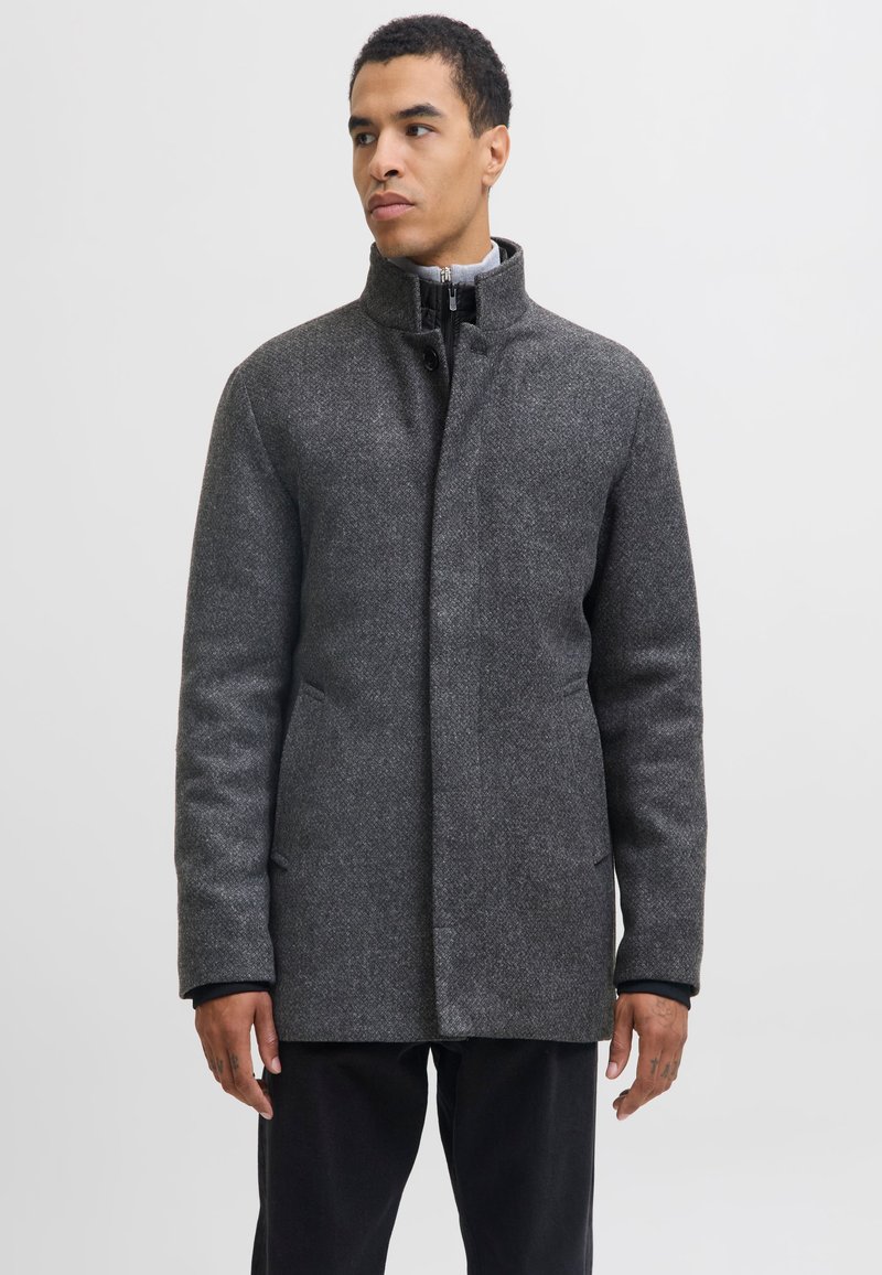 Hall triiksärgjas villane mantel kõrge krae, ees nupuga kinnitamine ja kaks küljetaskut. Sile tekstuur ja kohandatud lõige, sobib jaheda ilma jaoks.