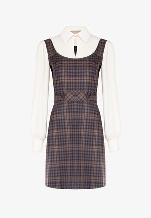 Robe sans manches à carreaux en violet foncé avec des motifs orange et gris, accompagnée d'un chemisier blanc à col et d'un détail en forme de goutte à l'encolure.