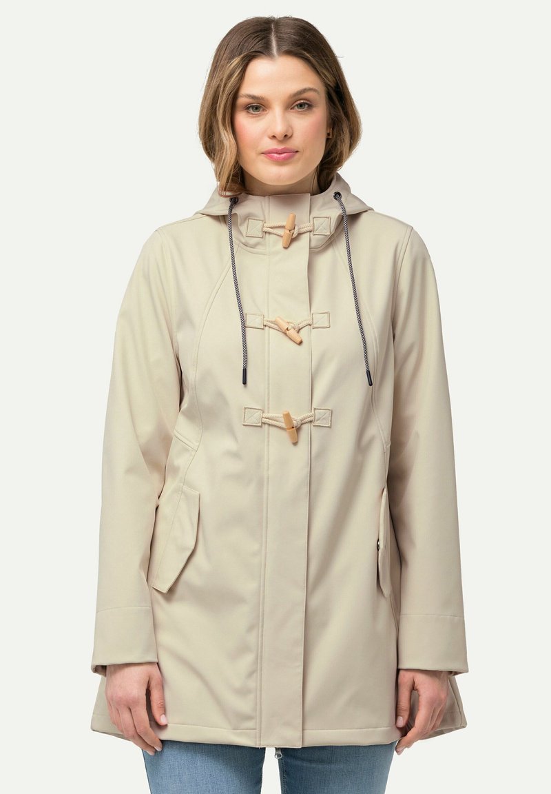 Impermeable beige con capucha, cierre de cordones y bolsillos frontales. Presenta una textura suave y cordones ajustables.