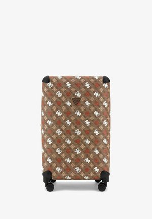 Grande valise marron avec motifs géométriques blancs et rouges, protège-coins noirs et quatre roues pivotantes noires.