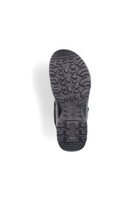 Semelle de chaussure en caoutchouc noir avec un motif de grip texturé mêlant formes ovales et angulaires pour une traction optimale. Design de semelle classique pour la stabilité.