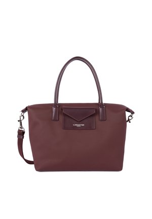 Borsa a tracolla bordeaux con un esterno testurizzato, doppio manico, una tracolla rimovibile e una tasca frontale con pattina. Dettaglio del logo argentato visibile.