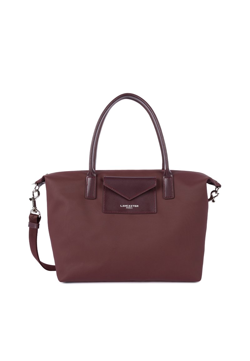 Borsa a tracolla bordeaux con un esterno testurizzato, doppio manico, una tracolla rimovibile e una tasca frontale con pattina. Dettaglio del logo argentato visibile.
