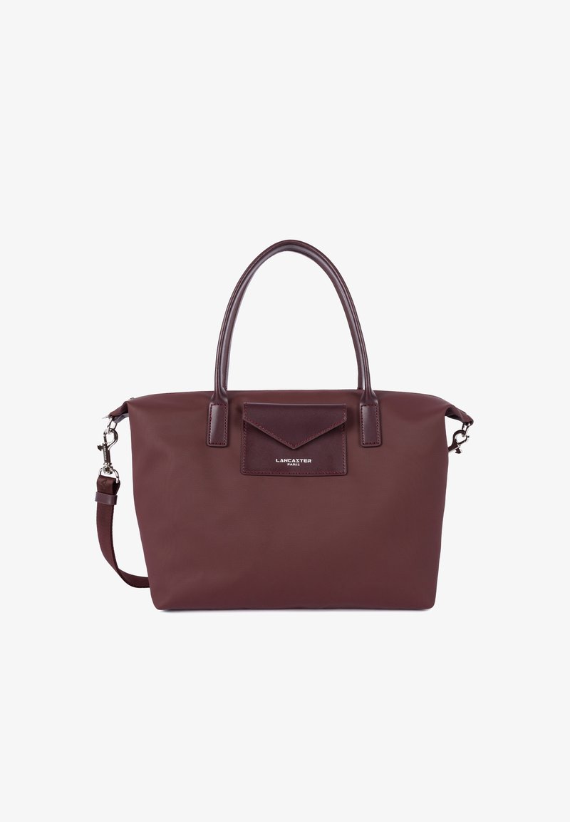 Borsa a tracolla bordeaux con un esterno testurizzato, doppio manico, una tracolla rimovibile e una tasca frontale con pattina. Dettaglio del logo argentato visibile.