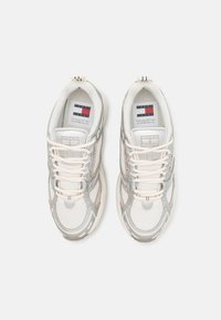 Białe i szare sneakersy z siateczkowymi i syntetycznymi materiałami, z jasnoróżowymi akcentami, grubymi sznurówkami i wyściełanym kołnierzem dla wygody.