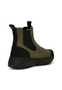 Bottine cheville vert olive avec des accents noirs, panneaux latéraux élastiques, talon texturé et semelle noire robuste. Dotée d'une languette pour un enfilage facile.