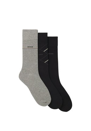 Tre paia di calze in grigio e nero. La calza grigia presenta un logo con una banda, mentre le calze nere hanno un motivo geometrico e un branding.