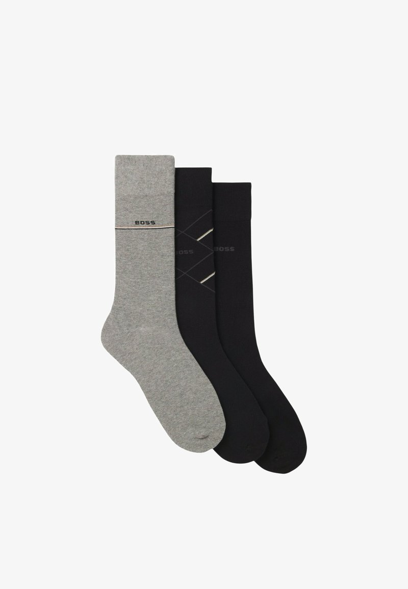 Trois paires de chaussettes en gris et noir. La chaussette grise présente un logo avec une bande, tandis que les chaussettes noires arborent un motif géométrique et un logo.