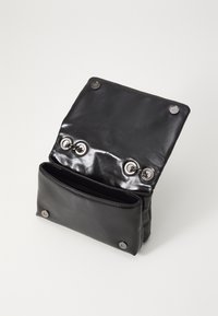Borsa nera in pelle con finitura lucida, dotata di chiusura a ribalta e due bottoni a pressione argentati. L'interno ha un unico scomparto principale.