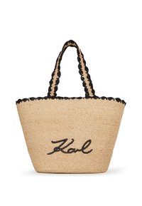 Dabīgā salmu soma ar melnu kantainu mežģīņu apdari, divām rokturiem un uzrakstu "Karl" melnā krāsā priekšpusē.