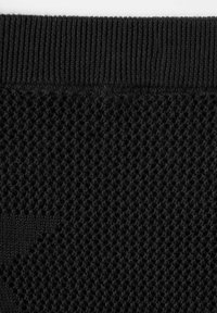 Tela de punto negra con un patrón texturizado, que presenta una pretina acanalada y una estructura similar a diamantes en el cuerpo principal.