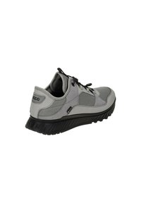Gray athletic shoe featuring a textured upper, black rubber outsole, and contrasting mesh panels with laces for secure fit.