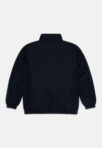 Marineblå polstret jakke med høj krave, elastiske manchetter og talje. Glat tekstur, ensfarvet design uden yderligere detaljer.