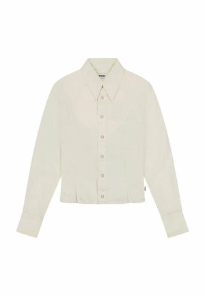 Beskarret, langærmet skjorte i lysecreme stof. Har en spids krave, knaplukning foran og detaljer med western-stil på yoke.