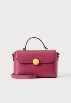 Kleine fuchsienfarbene Lederhandtasche mit Tragegriff oben, rundem goldfarbenem Verschluss und abnehmbarem Schulterriemen auf schlichtem Hintergrund.