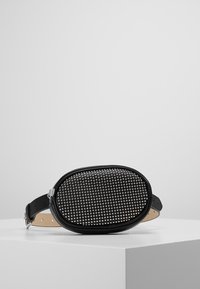 Schwarze ovale Tasche aus Leder mit einer gesteppten Vorderseite und einem verstellbaren Riemen. Glatte Textur mit metallischen Akzenten.