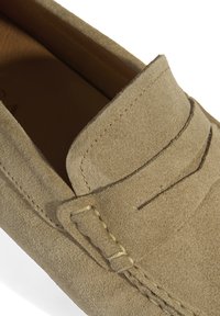 Wildleder-Loafers in Hellbeige mit gesteppten Akzenten und erhöhten Nähten auf der Oberseite. Glatte Innenauskleidung, zum Hineinschlüpfen.
