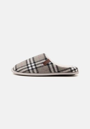 Chausson souple à enfiler avec motif à carreaux gris, noir et blanc et doublure en peluche blanche, présenté de profil sur fond blanc.