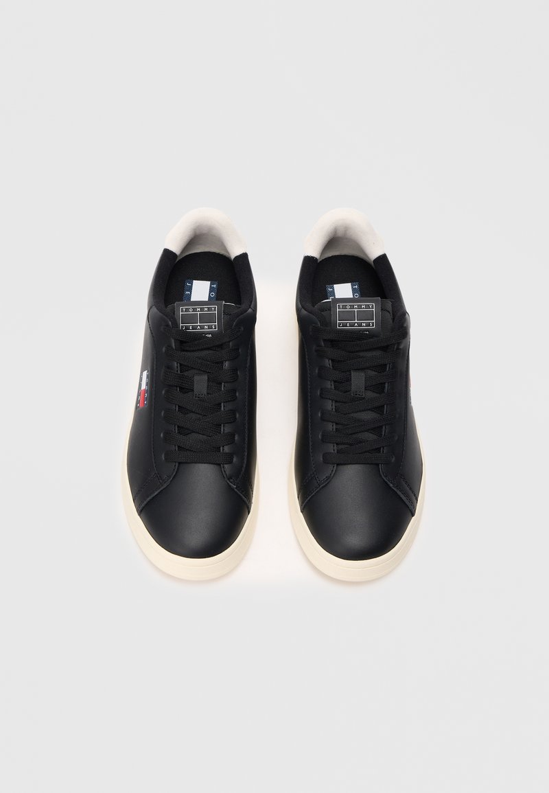 Black leather sneakers with a smooth finish, featuring white accent on the sole and branded tag on the tongue. Traditional lace-up design.