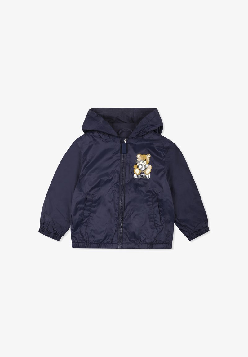 Giacca a vento blu navy con cappuccio, polsini elastici, zip frontale e grafica di un orso con la scritta "MOSCHINO" sul petto.