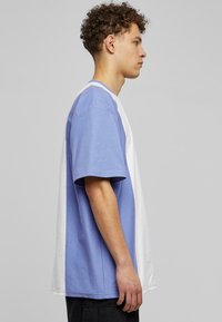 Kratkām piedurknēm T-krekls ar krāsu kombinācijas dizainu gaiši zili un baltā krāsā. Izgatavots no kokvilnas, ar brīvu piegriezumu un apaļu modeļa kakla izgriezumu.